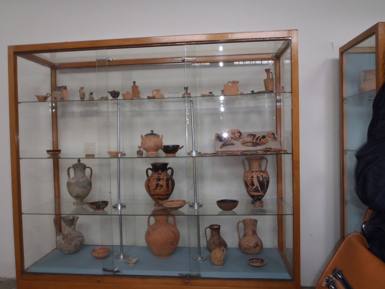 a wooden shelf that has many vases and bowls on it