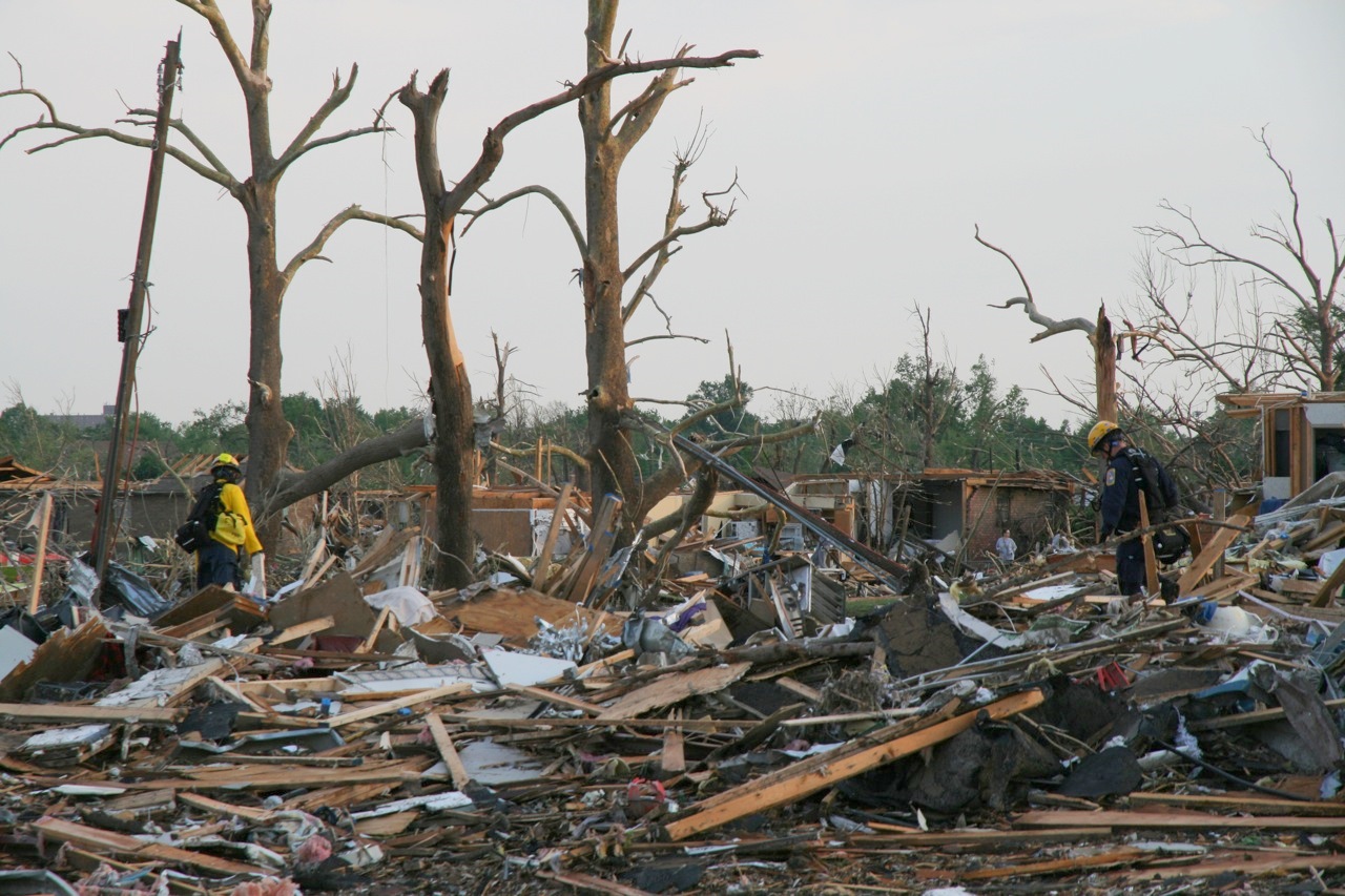 two workers in a large dump filled with rubble