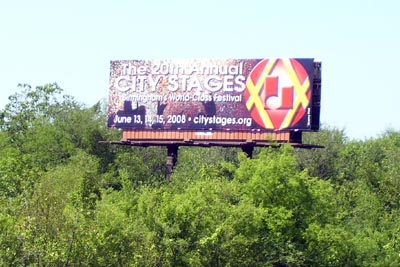 a billboard on the side of the road advertising an upcoming musical concert