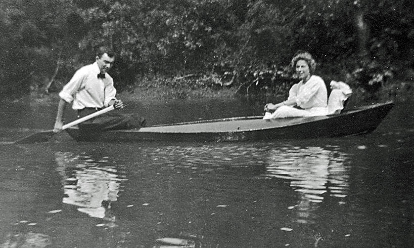 two people rowing a canoe down a river