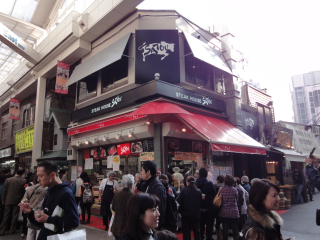 a crowded sidewalk in front of an asian restaurant