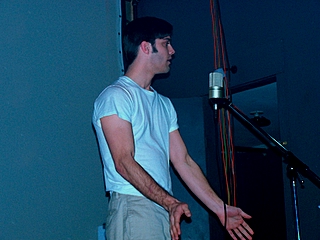 the young man is listening in his home recording studio