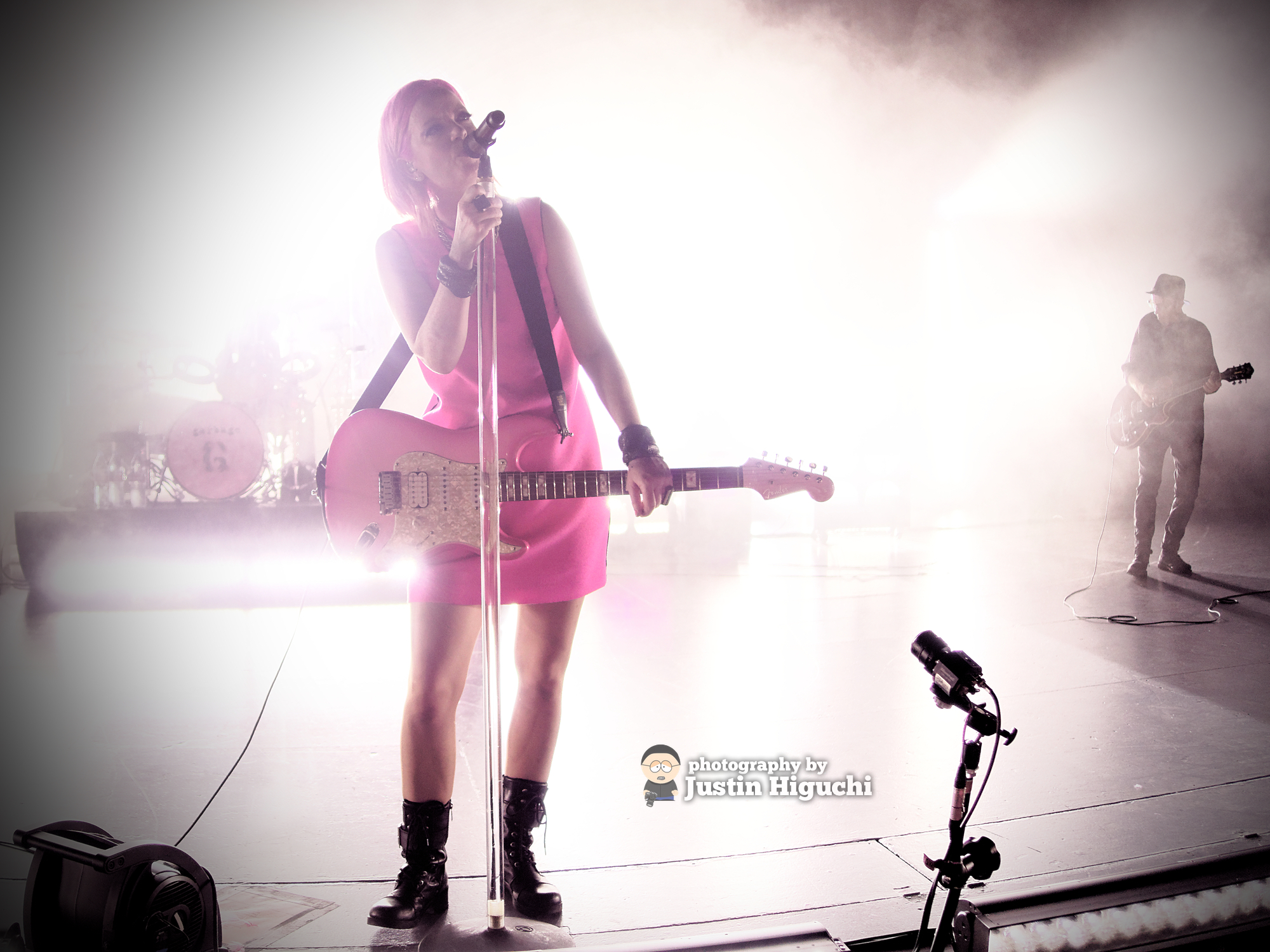 a person with a guitar standing on stage