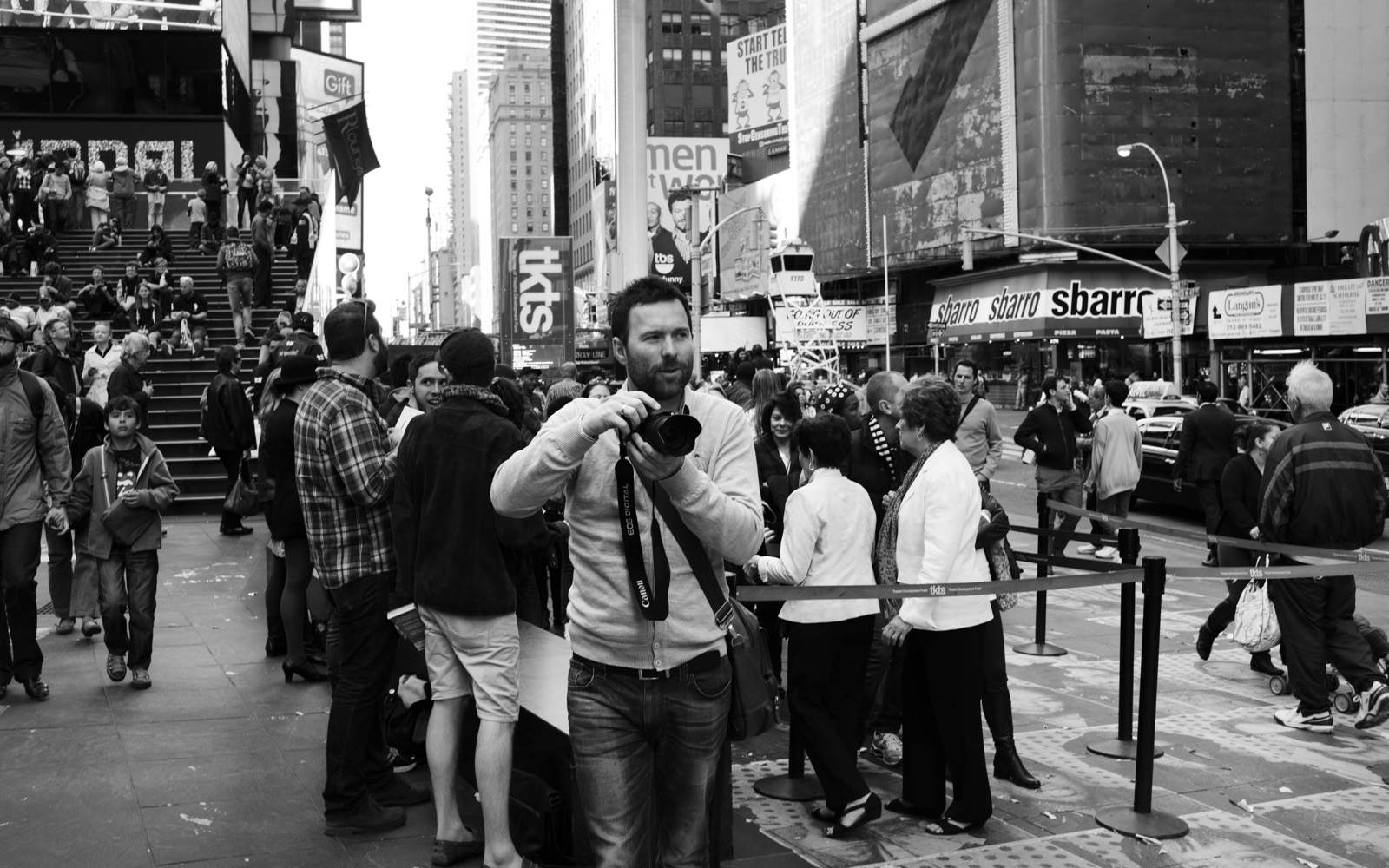 a man holding up a camera near many people