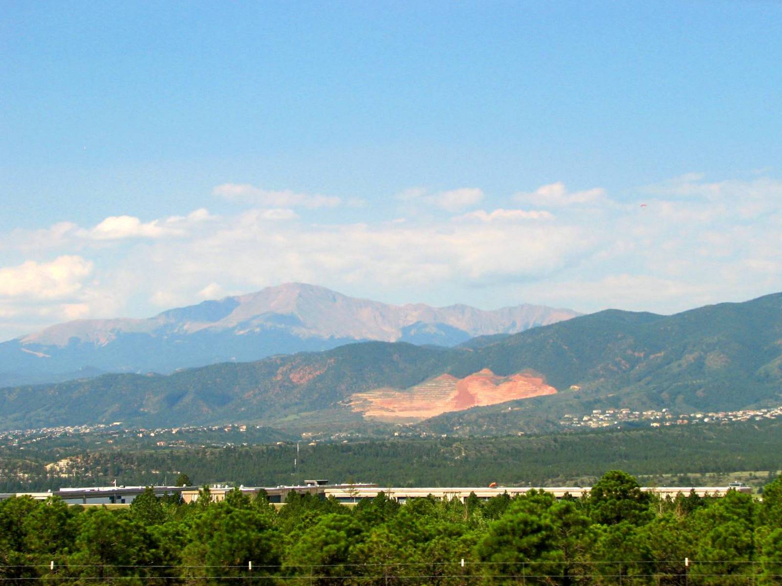 a view of the mountains in the distance with trees all around
