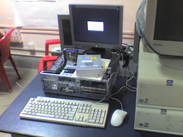 some computer screens and computers are on the desk