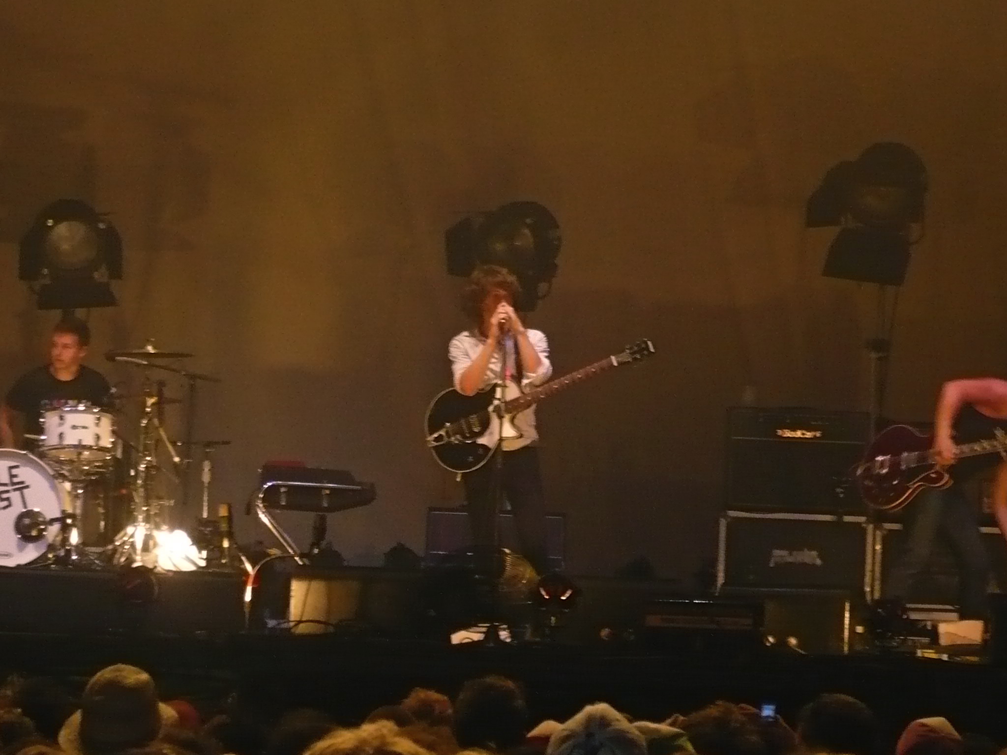 three men are performing on stage with guitars