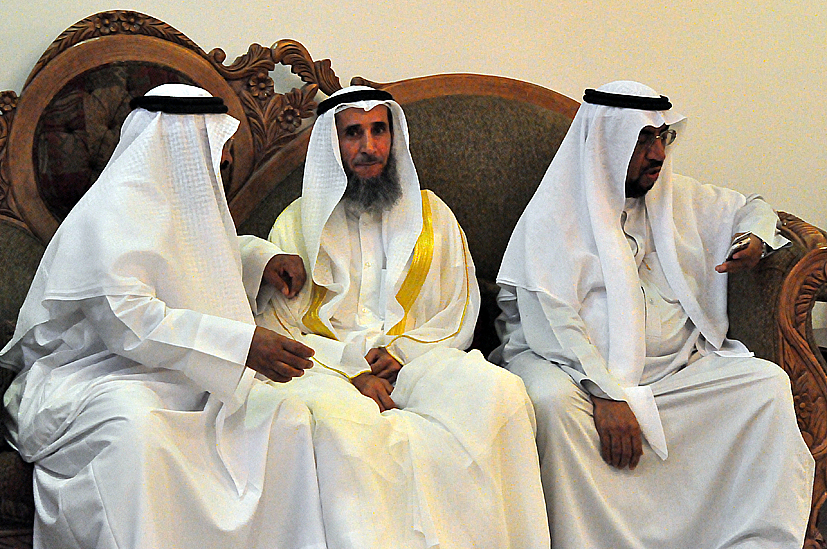 two men in white sit on a couch together