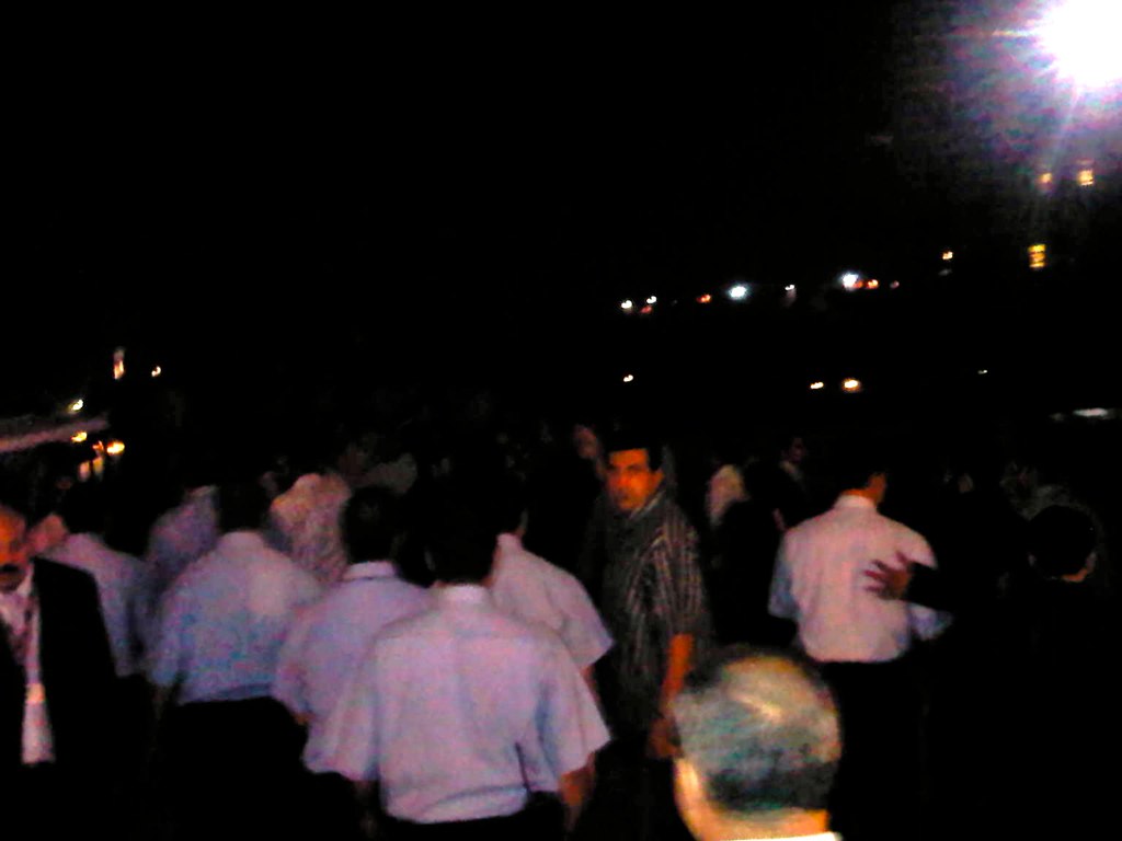 a large group of people standing in a dark field