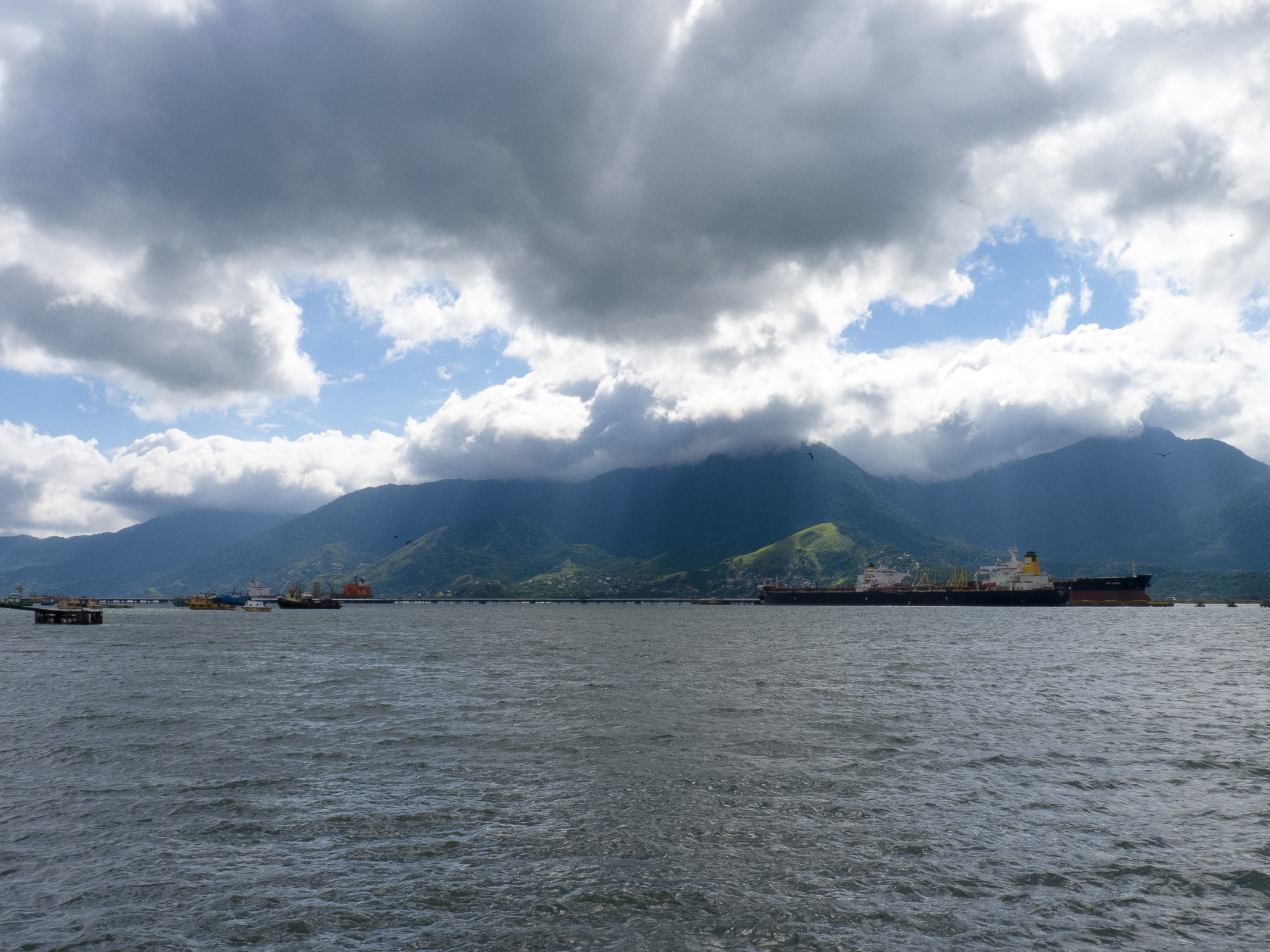 boats sailing in the water under a cloudy sky