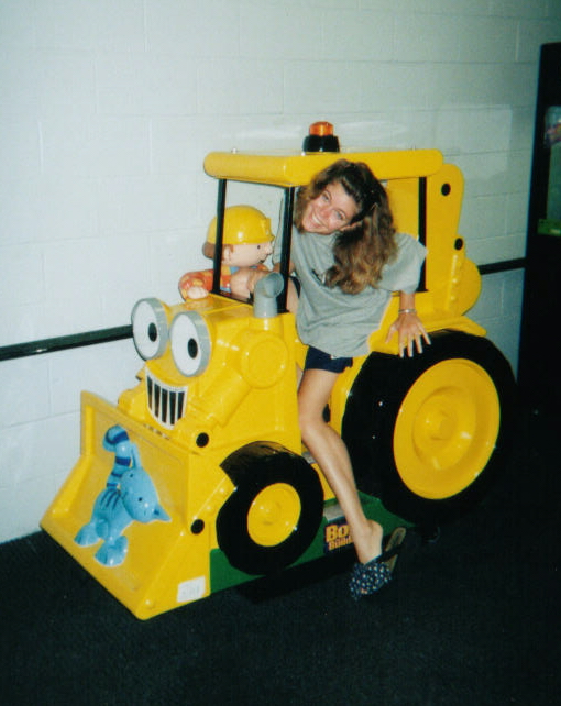 a woman riding on the back of a giant yellow vehicle