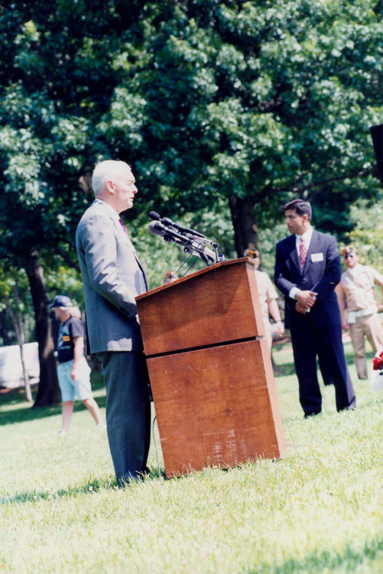 a man is standing behind a podium while people look on