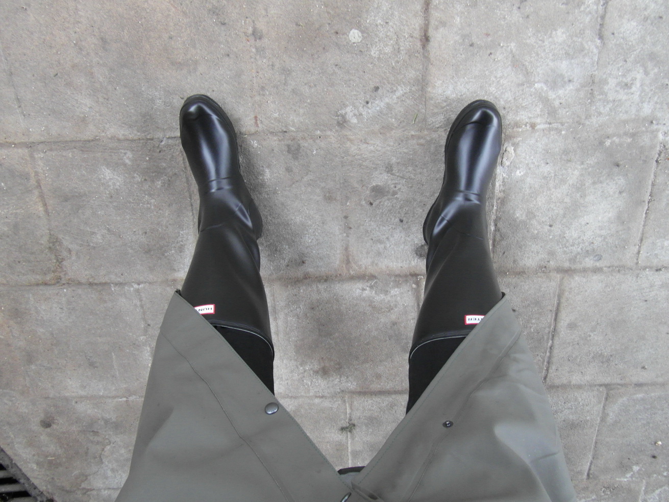 a person is standing on pavement with their feet propped up