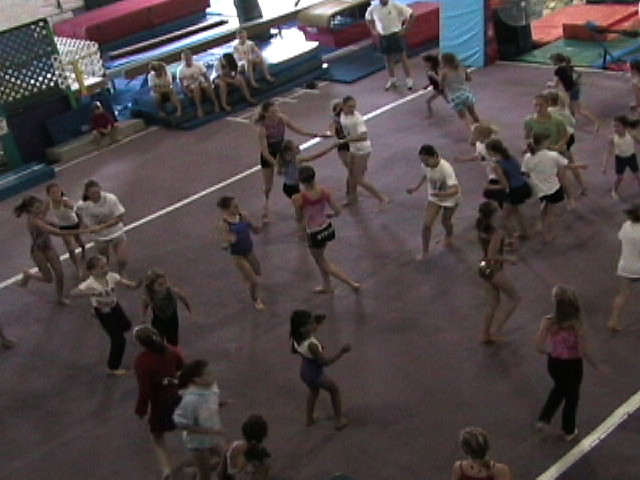 several young adults and children dancing on a dance court