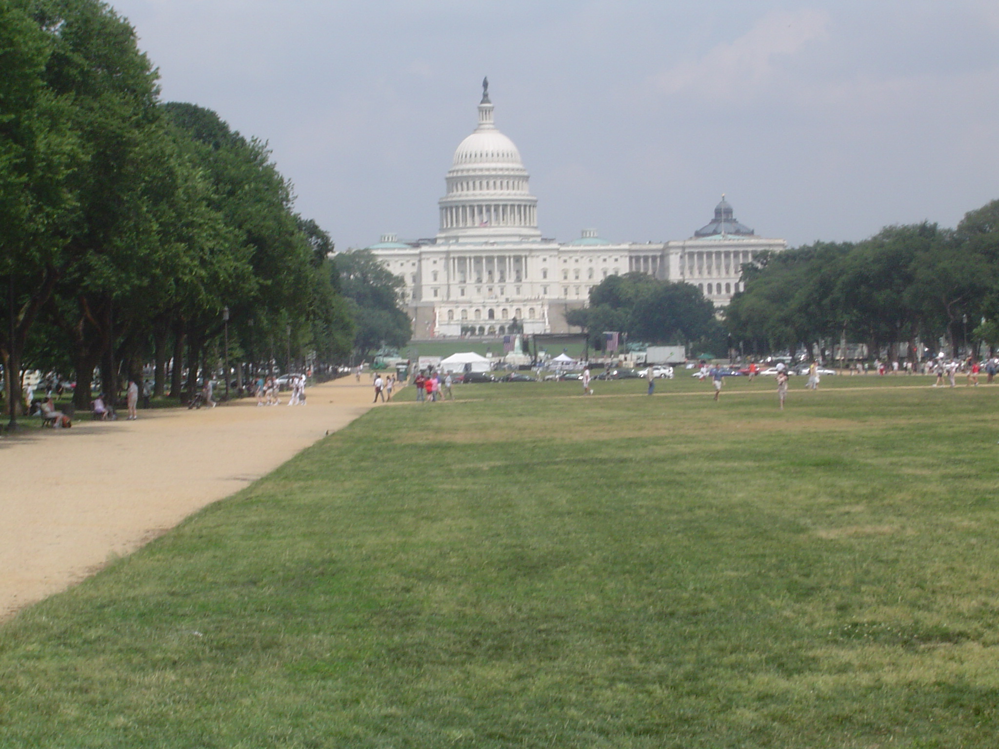 several people walking in the grass near the capital building