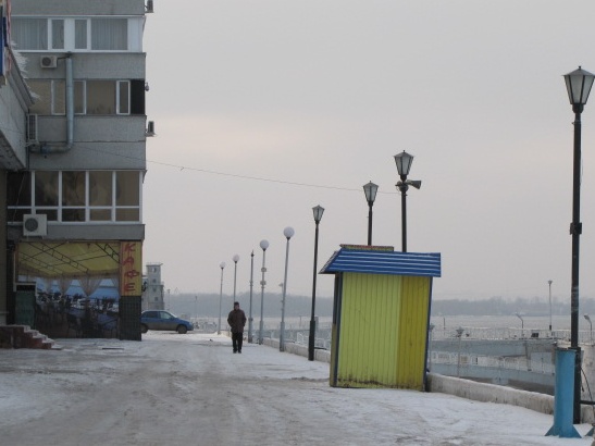 a street in a city with the lights on and the snow covering the street