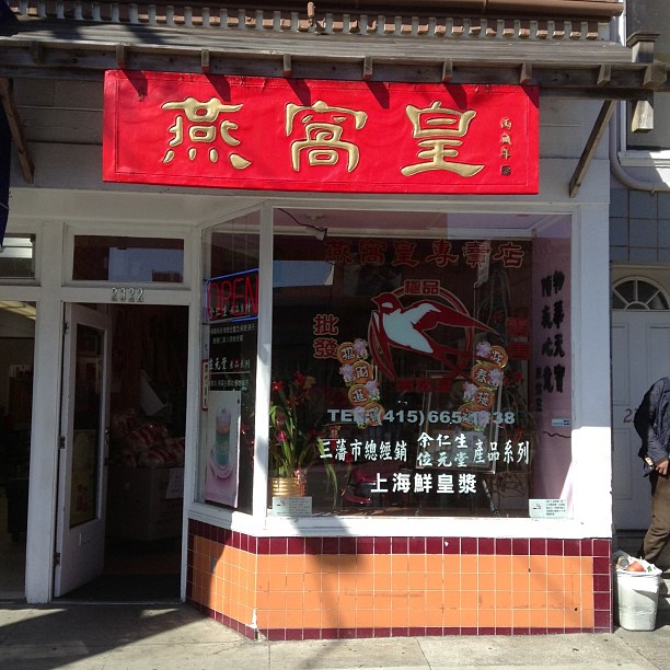a store front with a bright red chinese flag on top