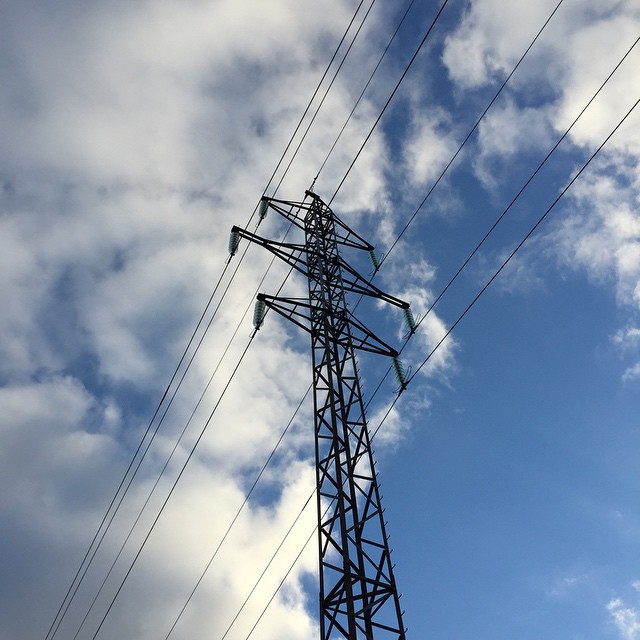 a large power line is high up in the sky