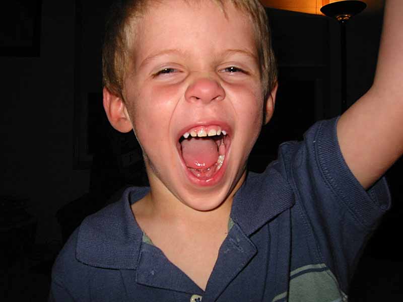 a boy holding a cell phone up to his ear