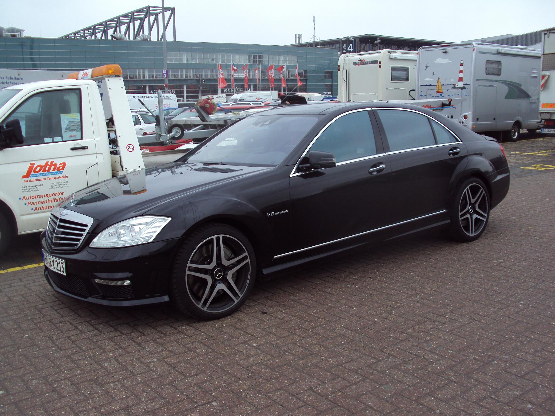 a car is parked in front of a vehicle with traileres