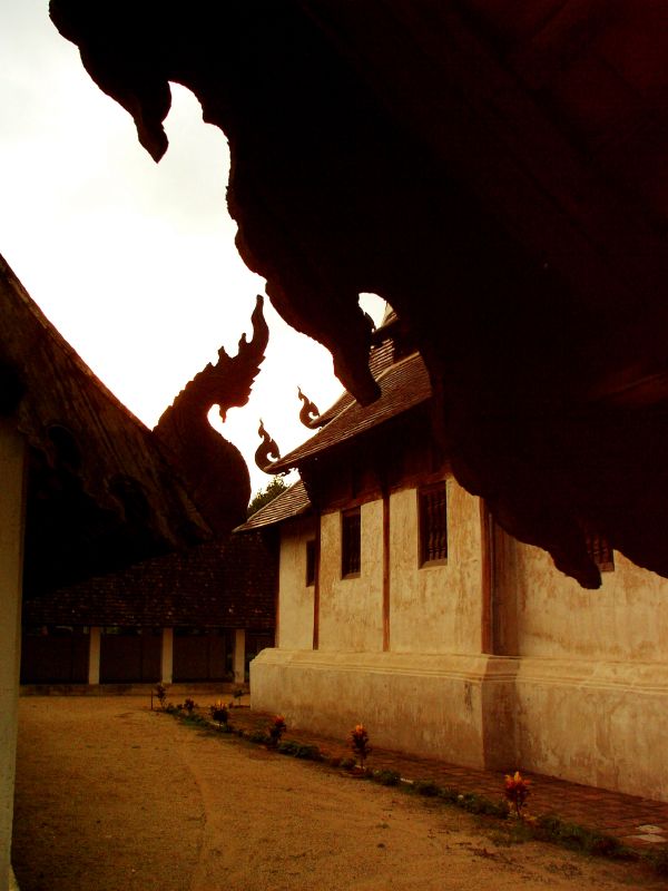 the silhouette of an old building with a stone wall and roof