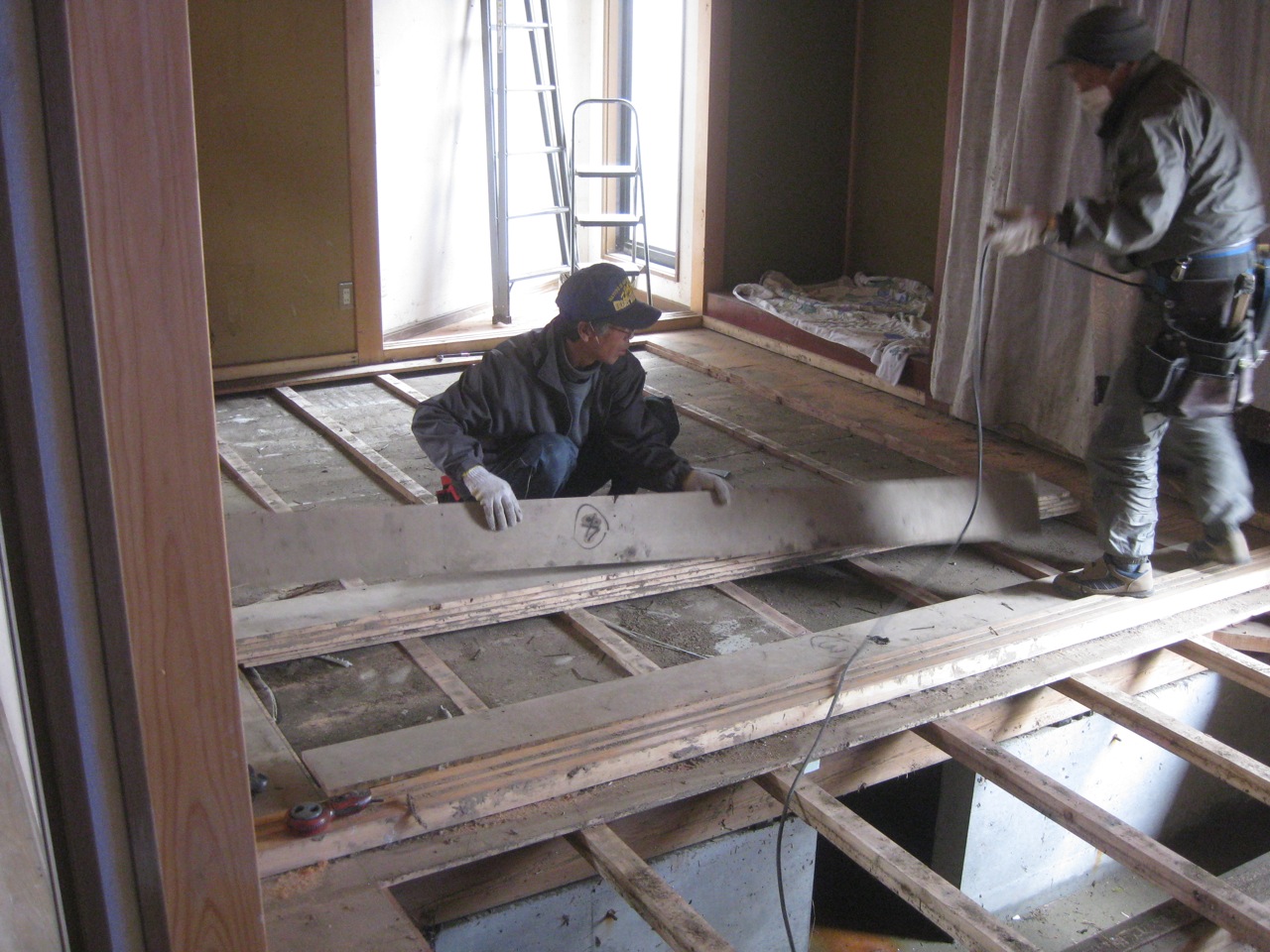 two construction workers working on an unfinished house