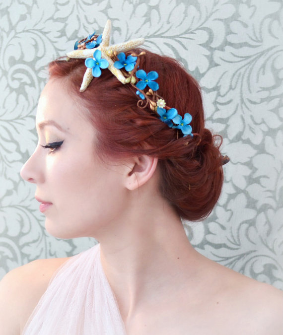 a woman wearing starfish shells with blue flowers on her hair