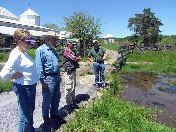 several people standing on a small bridge next to a river