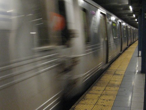 a train is passing by the platform in a subway station