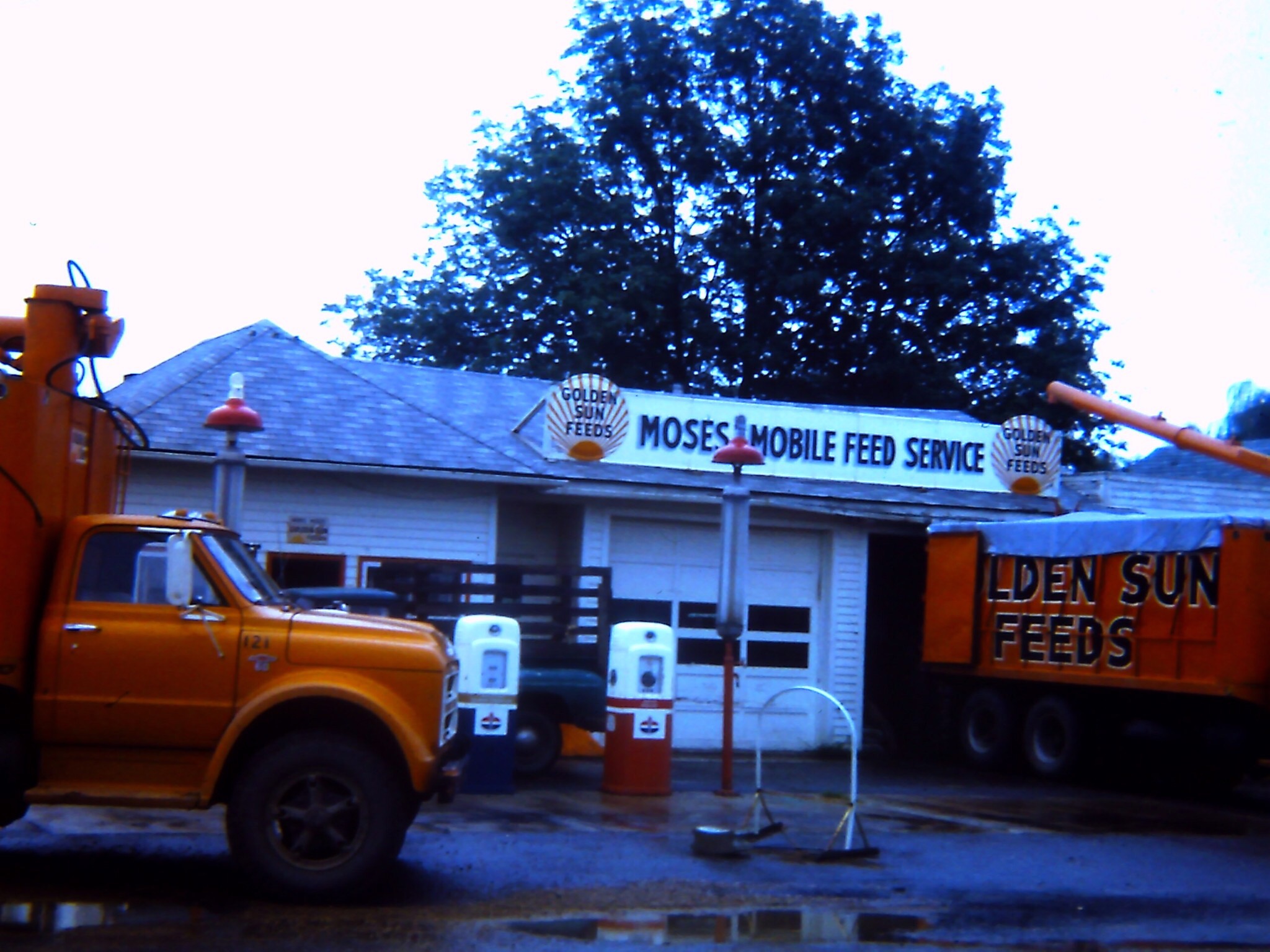 an orange truck parked next to a mobile feed service building