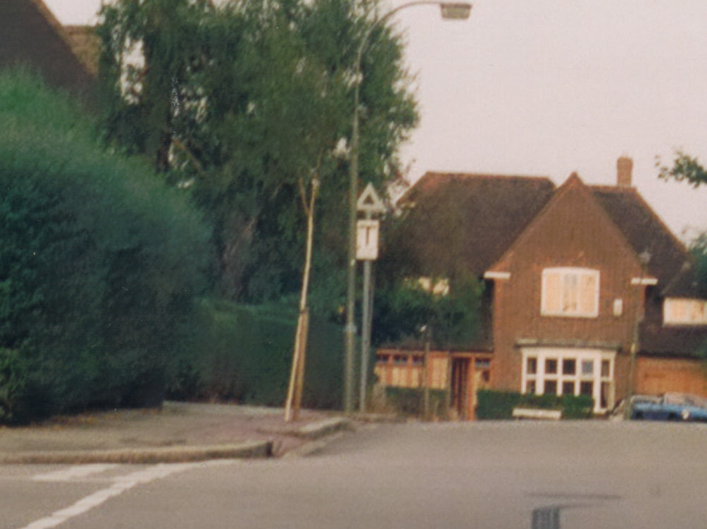 a street sign is shown in front of the small house