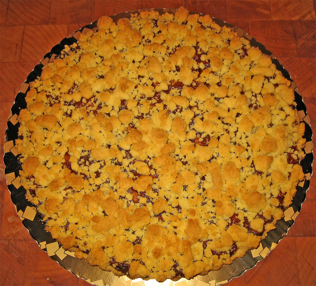 a pie covered in crumbs and toppings on a red table