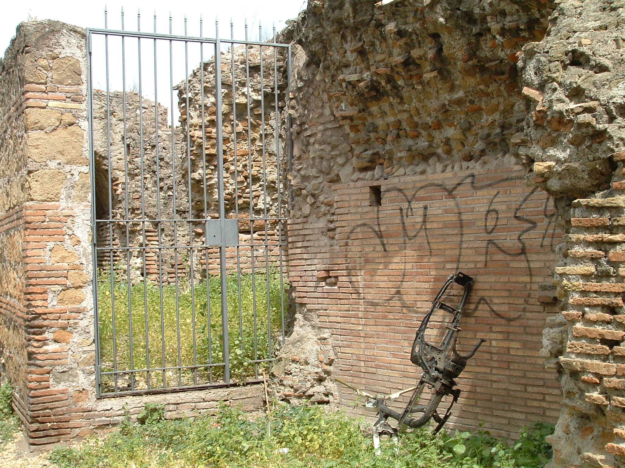 the brick wall and gate in an old cemetery