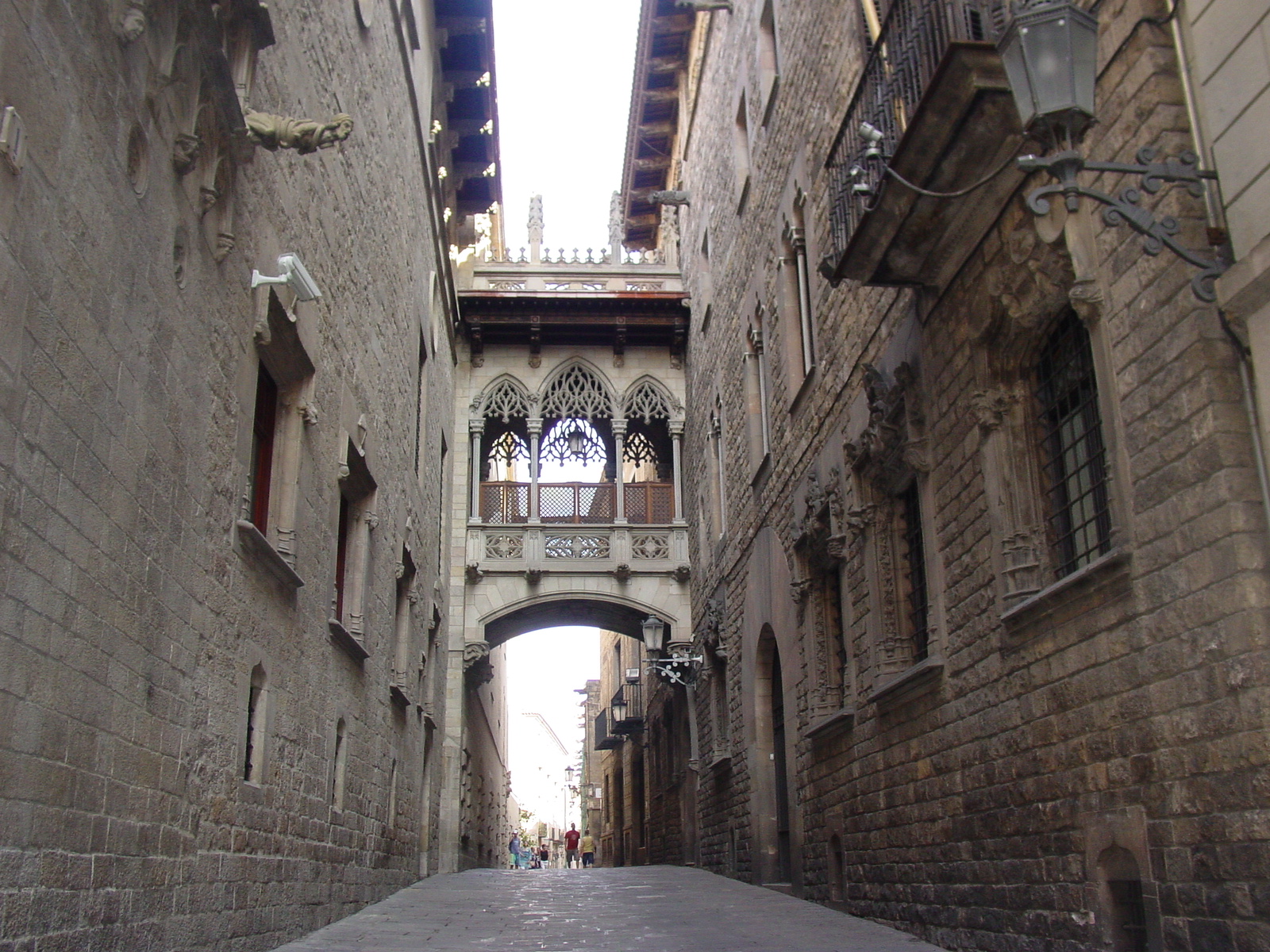 an alleyway with a narrow bridge between two buildings