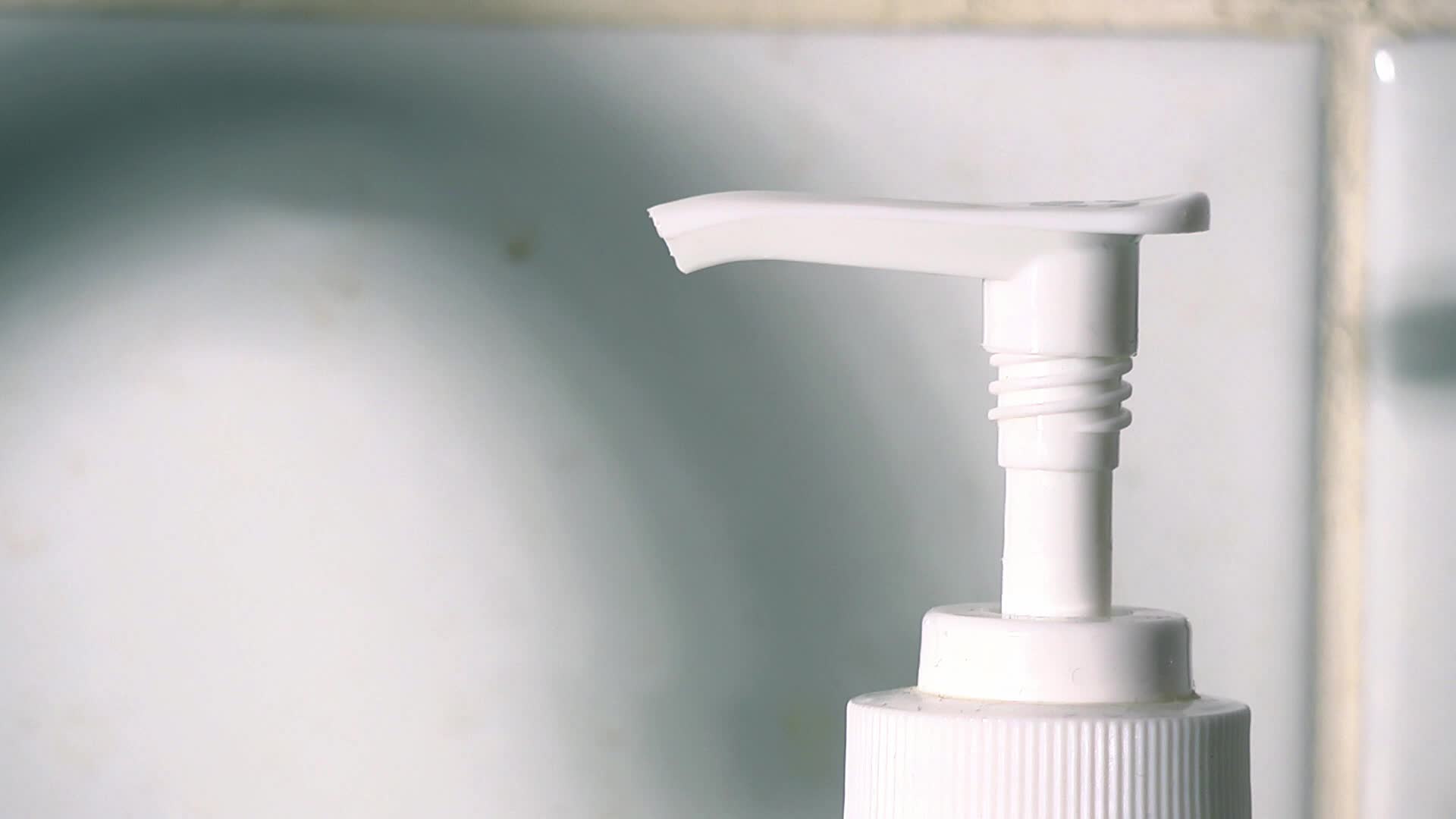 a white soap dispenser is against a tile wall
