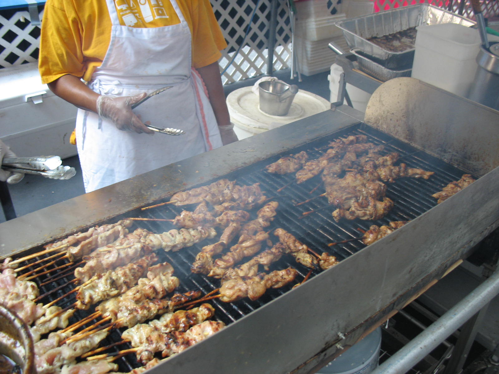 the man is preparing the barbecue grill for the customers