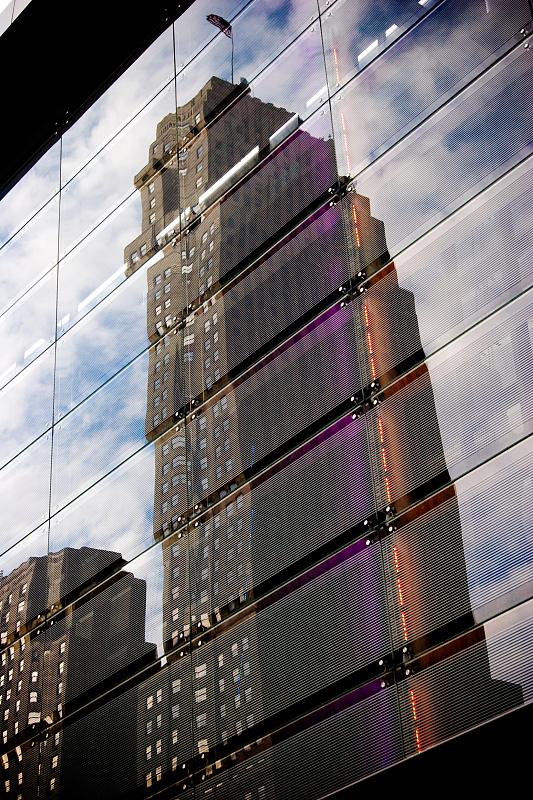 the reflection of a very tall skyscr in a building window