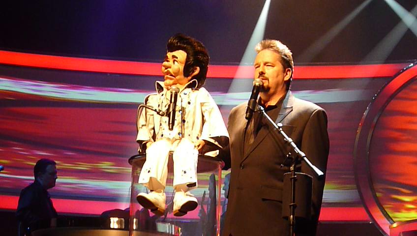 two people with microphones standing on stage