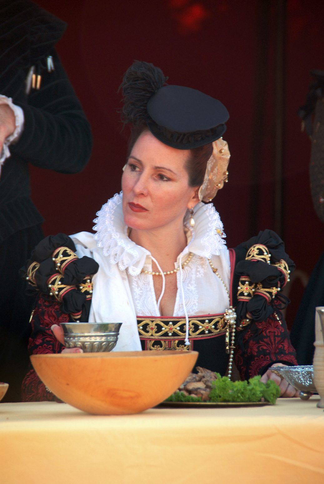 a woman dressed in historical costume at a table