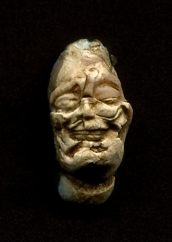 an antique piece of stone carved to look like an old man