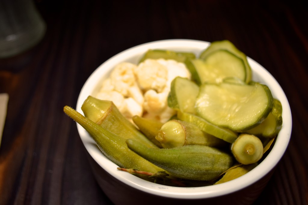 small bowl filled with sliced pickles and diced onions