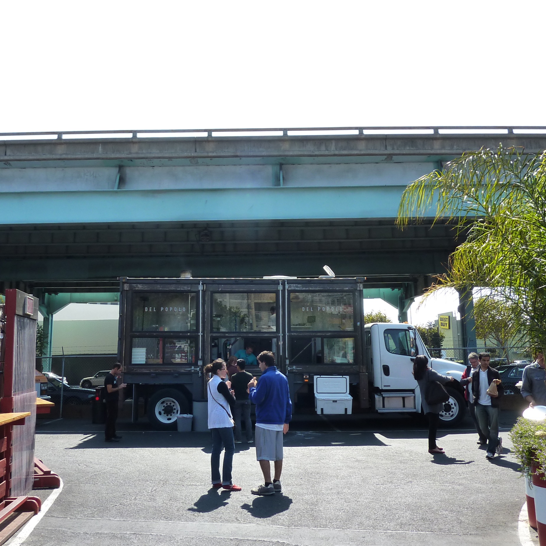 several people standing around looking at large transport vehicles