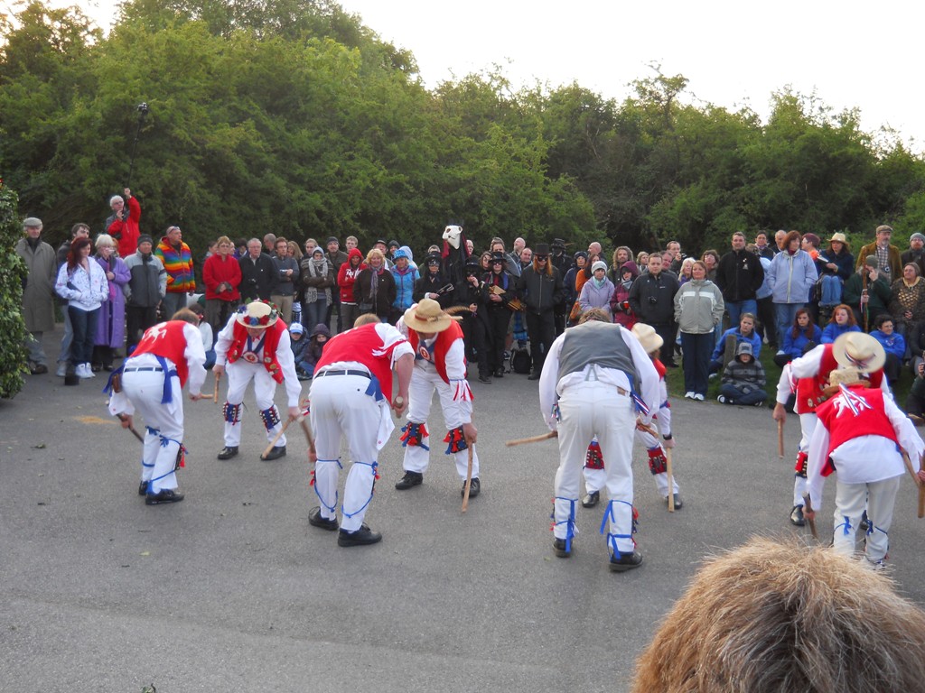 several people in a street with a group of dancers