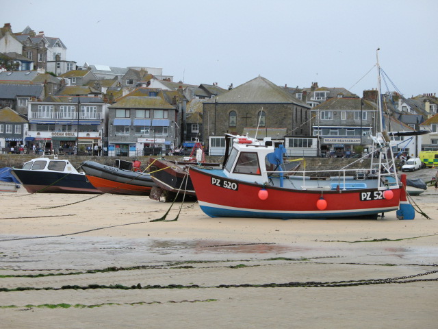 fishing boats are anchored on the shore in front of buildings
