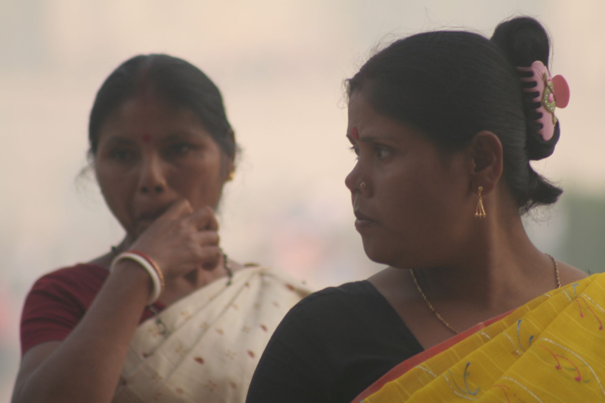 two indian women with head wraps are sitting