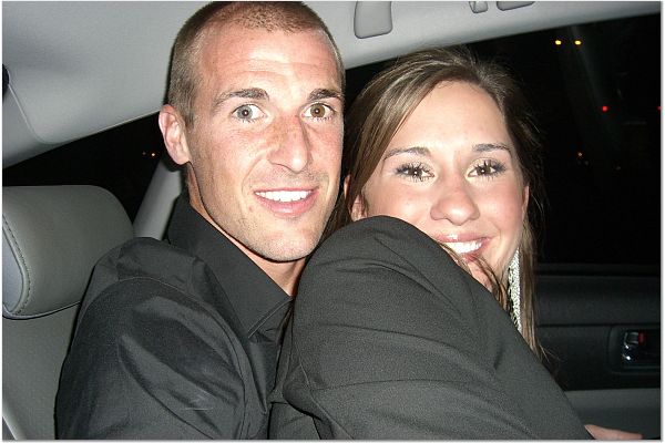 a man and woman smiling together in the back of a car