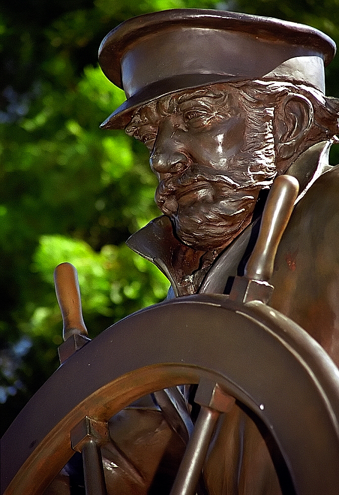 a metal sculpture of a man with a hat
