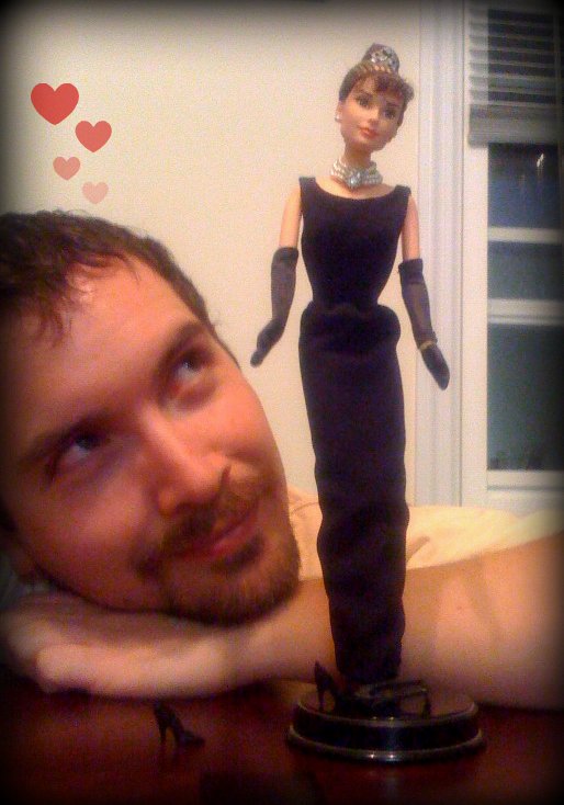 a man poses next to an action figure of a woman
