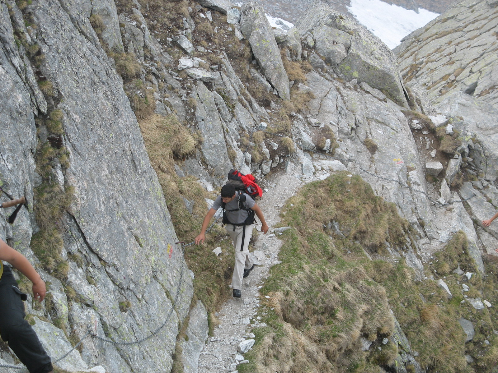 a man climbing a rocky mountain with his backpack