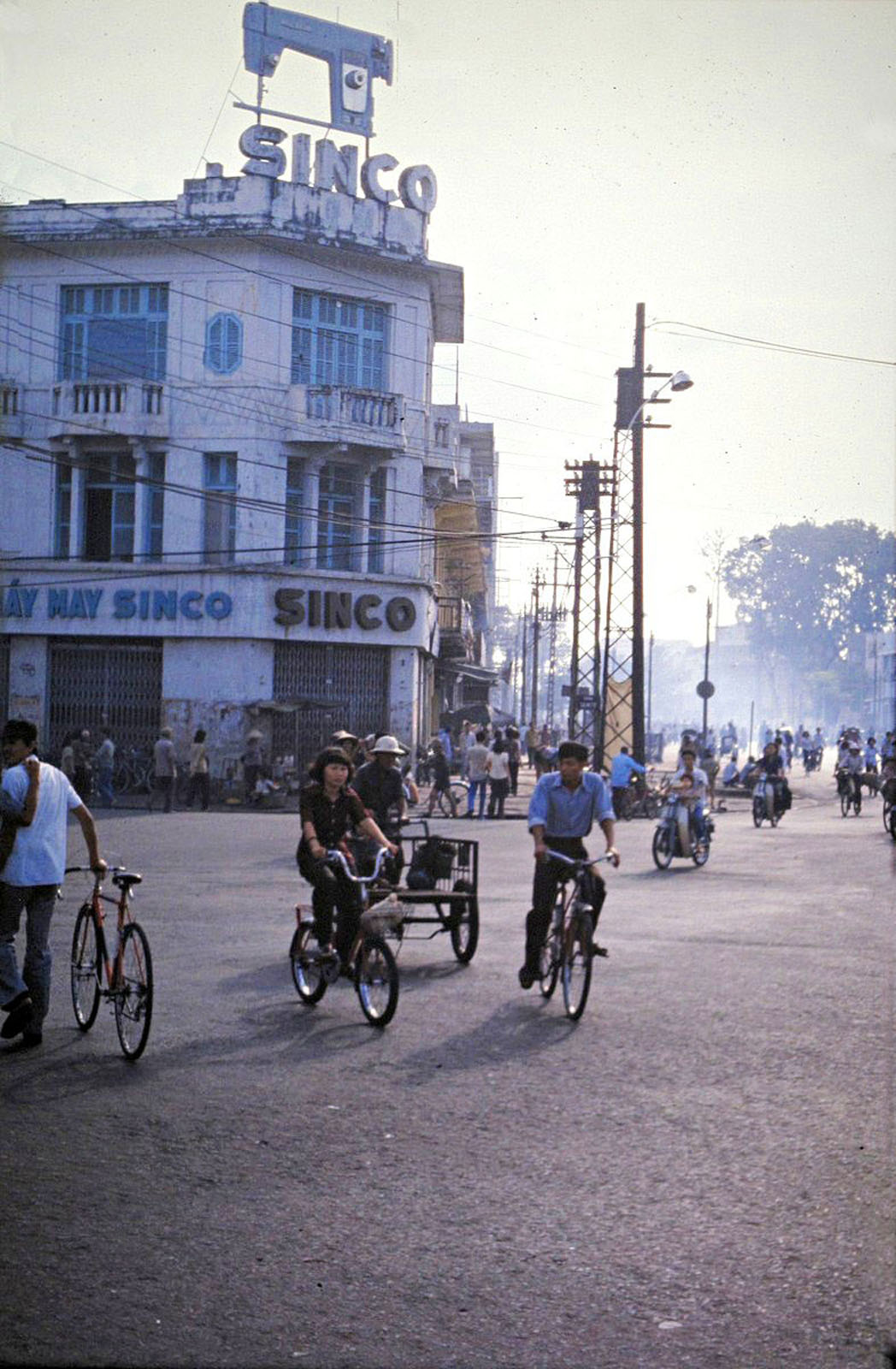 several people are riding bicycles and riding down the street